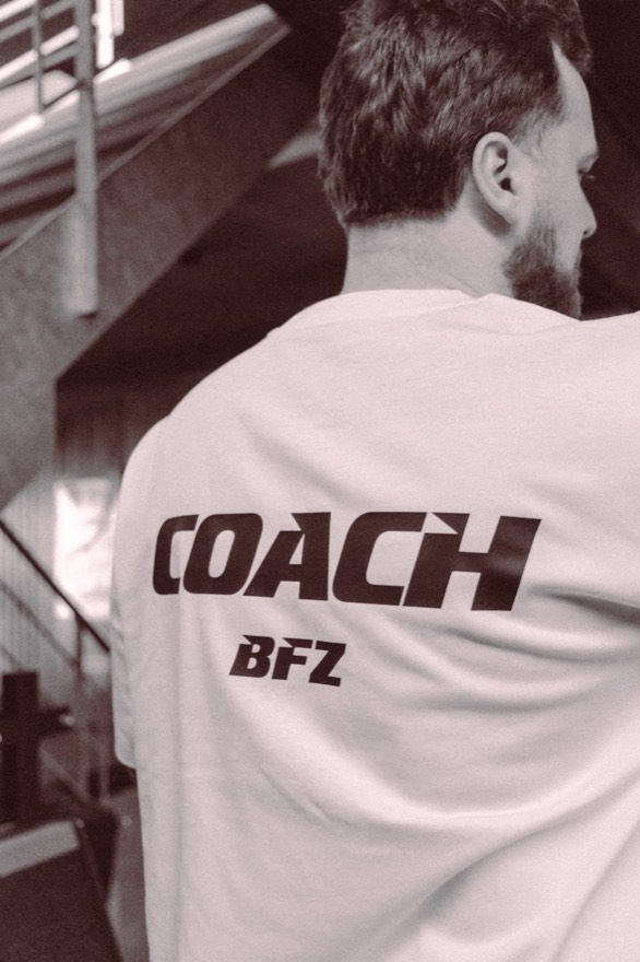 Coach in a BFZ COACH shirt on the club staircase