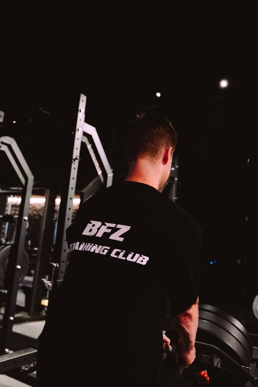 Member in a BFZ Training Club shirt at the squat rack