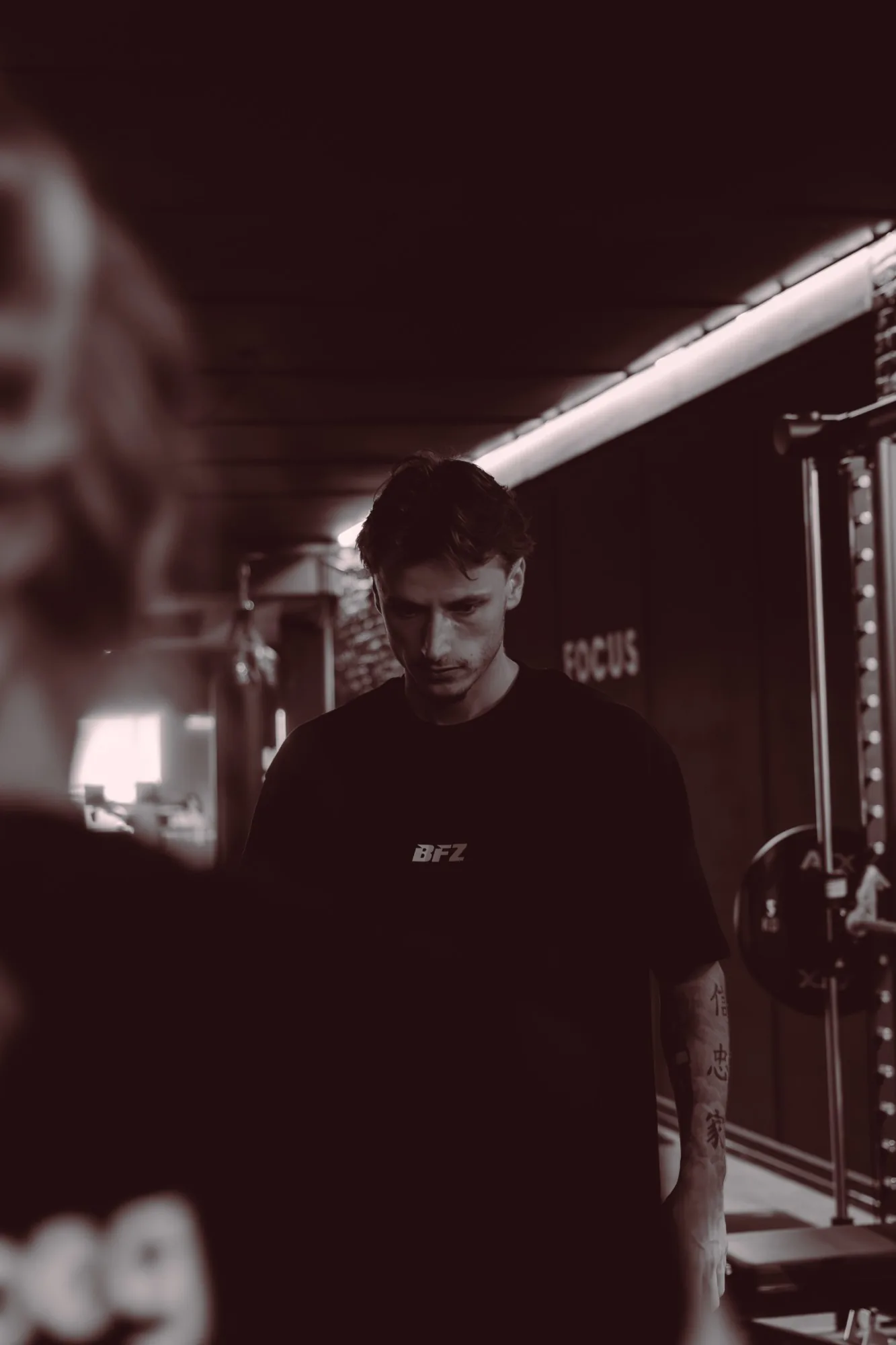 Coach in a BFZ shirt at the FOCUS wall, concentrating during a session